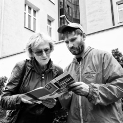 Dwie osoby pochylone nad katalogiem OPEN CITY