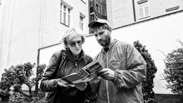 Dwie osoby pochylone nad katalogiem OPEN CITY